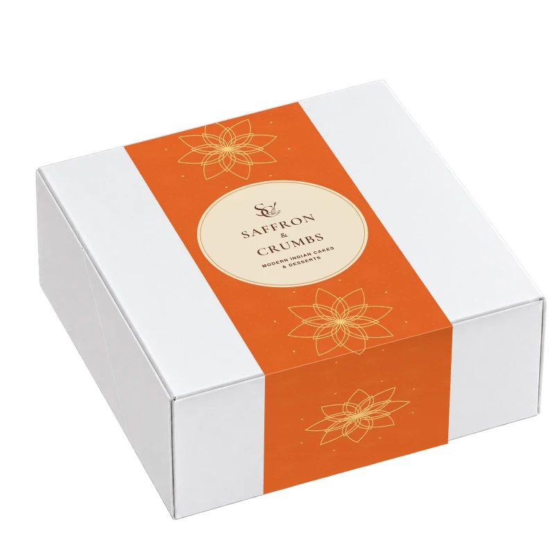 White product box wrapped in the signature saffron-orange Saffron and Crumbs floral belly band